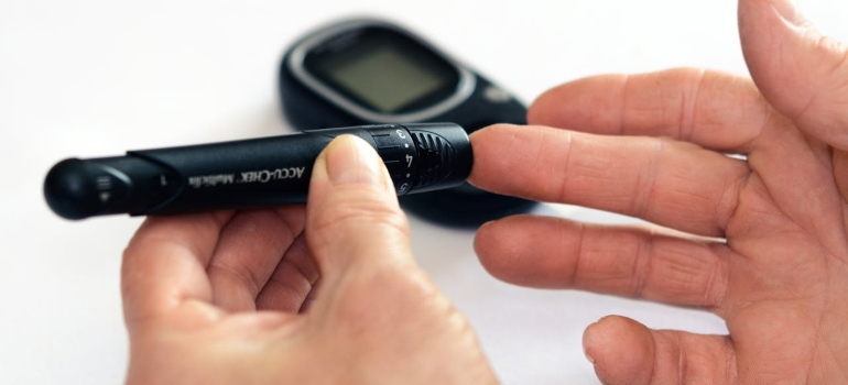 A hand holding a blood sugar pen