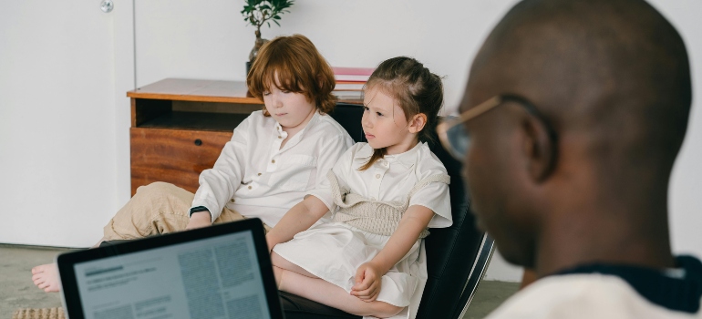 A boy and a girl are sitting together at the therapy session.