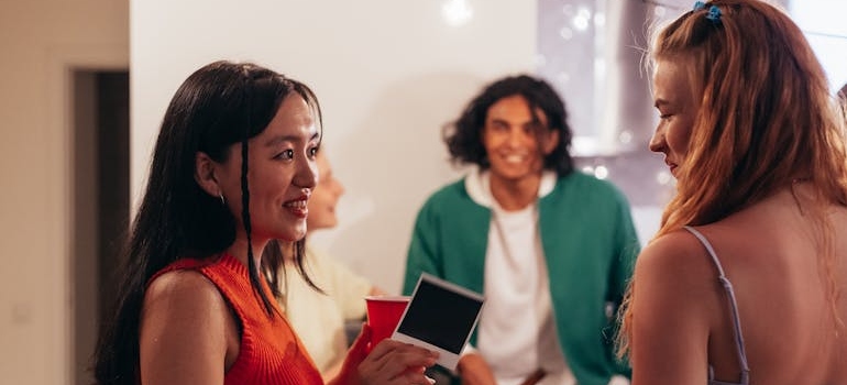 Two friends talking while attending a party.