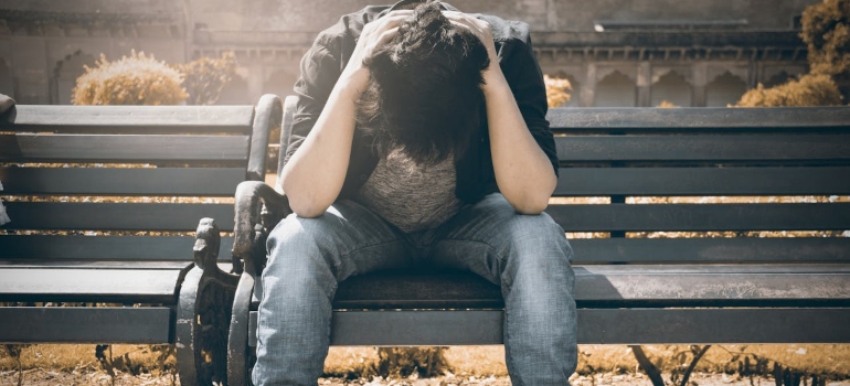 a depressed man sitting on a bench