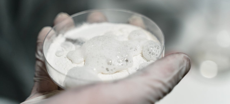 a man holding a white powder in a bowl