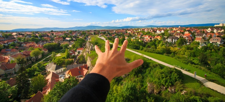 a man stretching a hand above a village