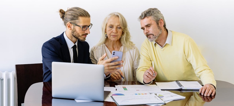 a businessman showing an elderly couple how to Prevent Surprise Medical Bills in Rehab