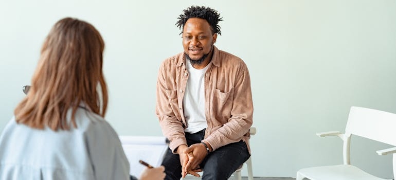 Man sitting on a chair and talking to his therapist about drinking mocktails in recovery.