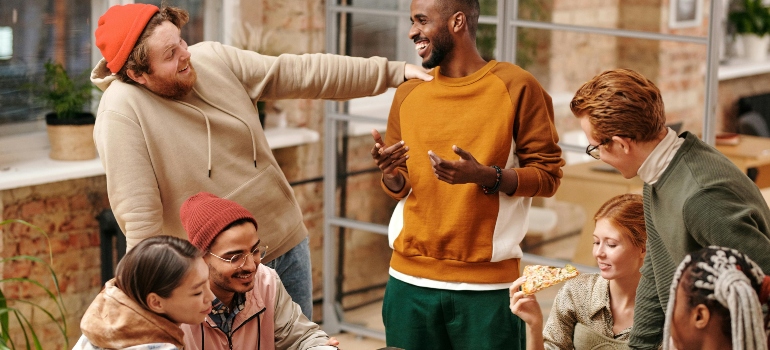 A group of people are smiling and having a conversation at a restaurant.