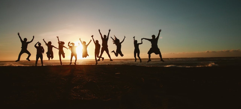 people looking at the sunset and jumping