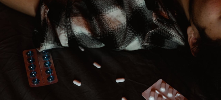 a man lying on the floor with drugs around him