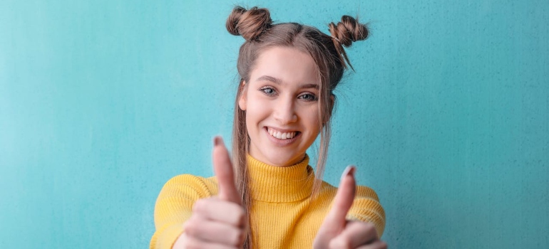 a cheerful girl giving thumbs up