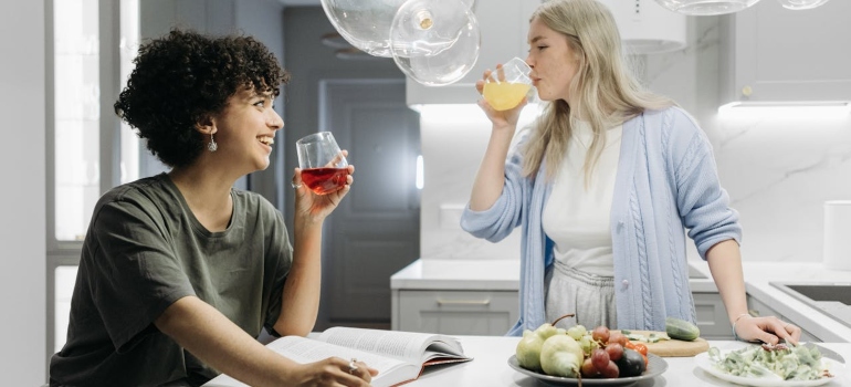 two girls drinking juice in the kitchen