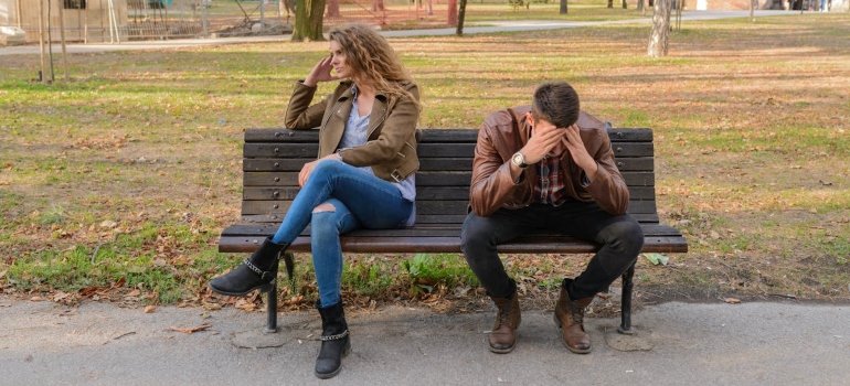 a couple sitting on the bench and arguing