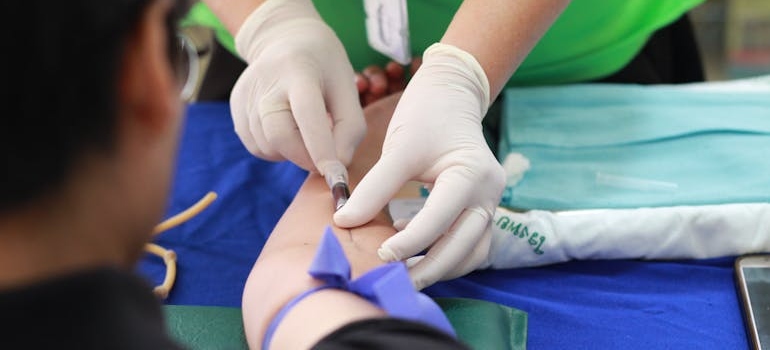 Man getting his blood drawn while getting help for drugs and skin sores.