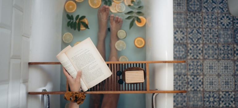 A woman reading a book in a bathtub