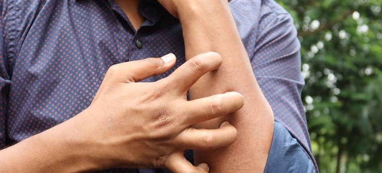 Man scratching his forearm.