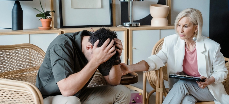 A woman therapist sits with her patient and gives support during the recovery process.