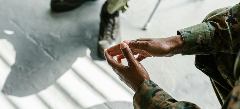 A veteran is sitting and crossing his hands.