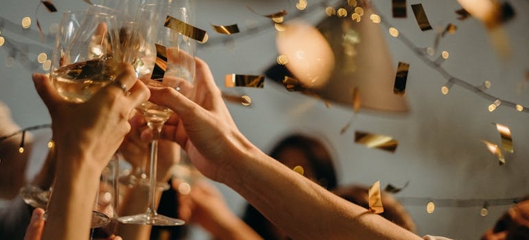 People toasting with glasses of white wine.