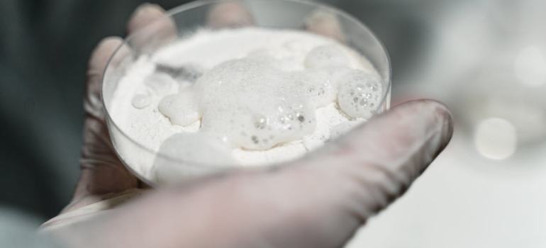 a hand holding a glass with cocaine