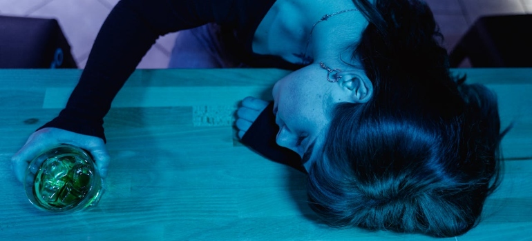 a girl sleeping at the counter after mixing Antipsychotics and Alcohol