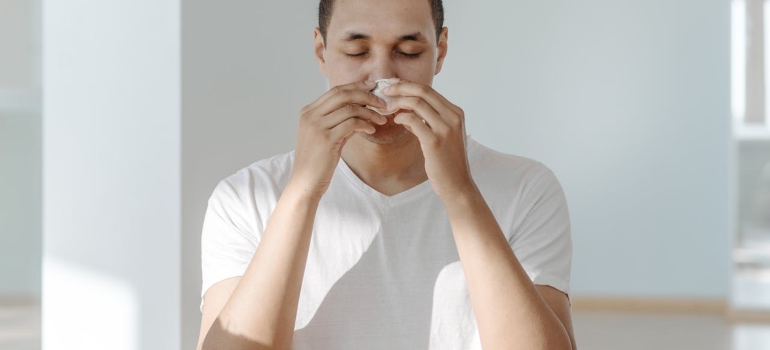 a man holding a tissue to his nose