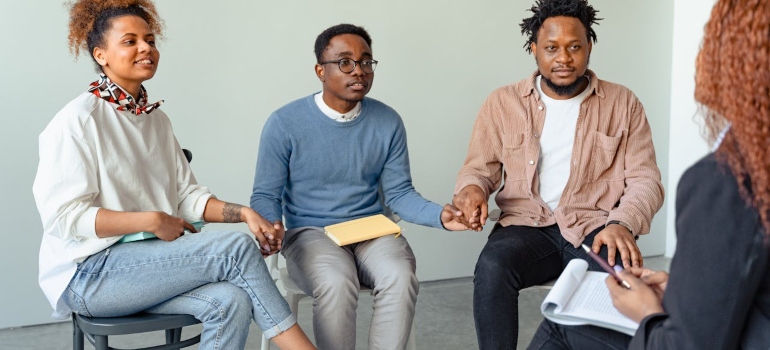 people holding hands in a support group meeting